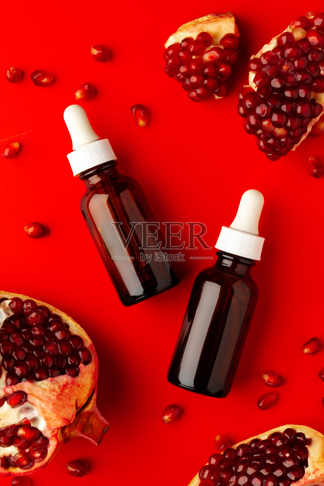 化妆品血清滴管瓶石榴味在红色背景照片摄影图片