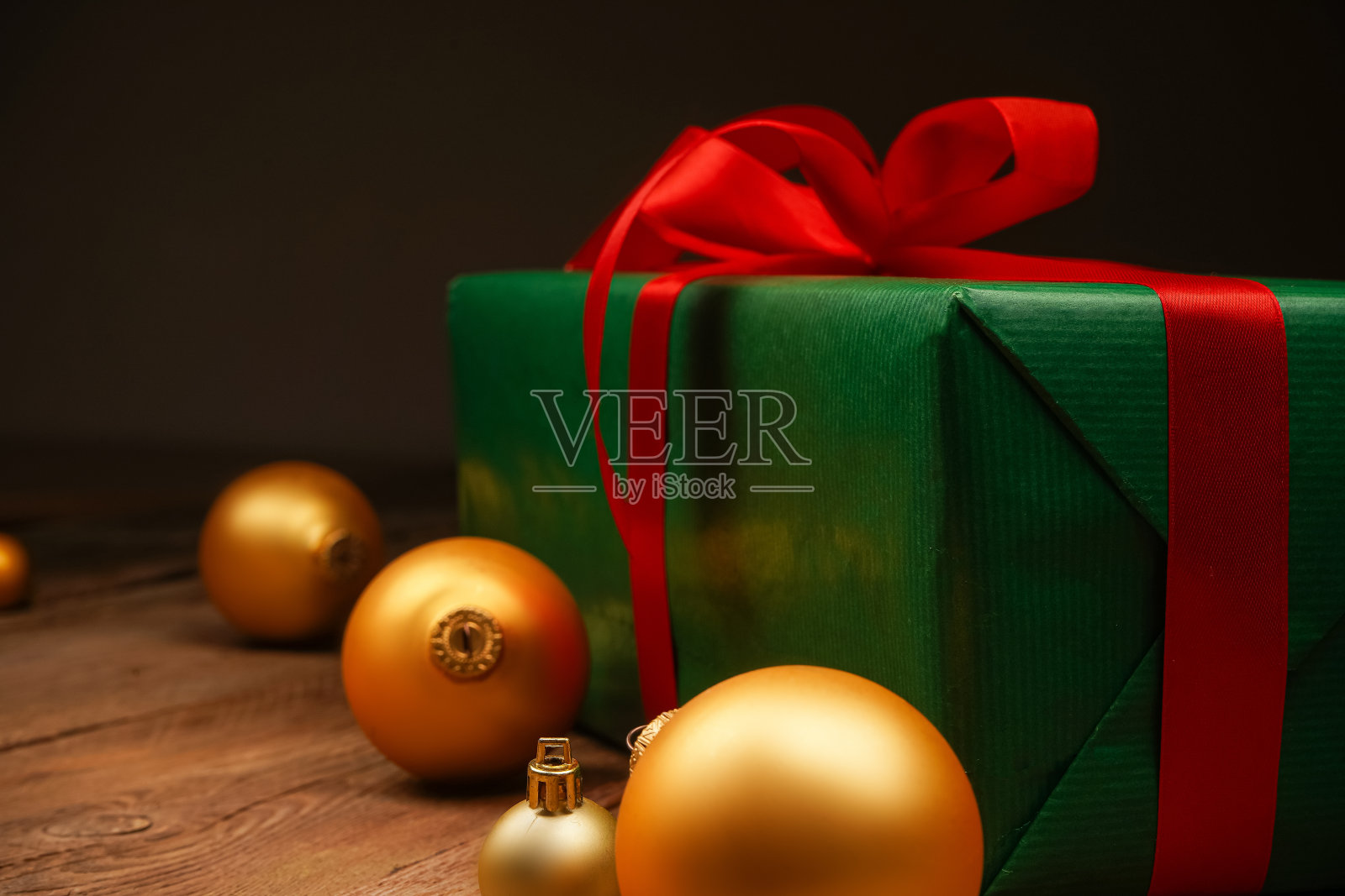 木制背景上的节日礼盒和金色圣诞树装饰。节日的概念。圣诞节、新年、生日、妇女节。照片摄影图片
