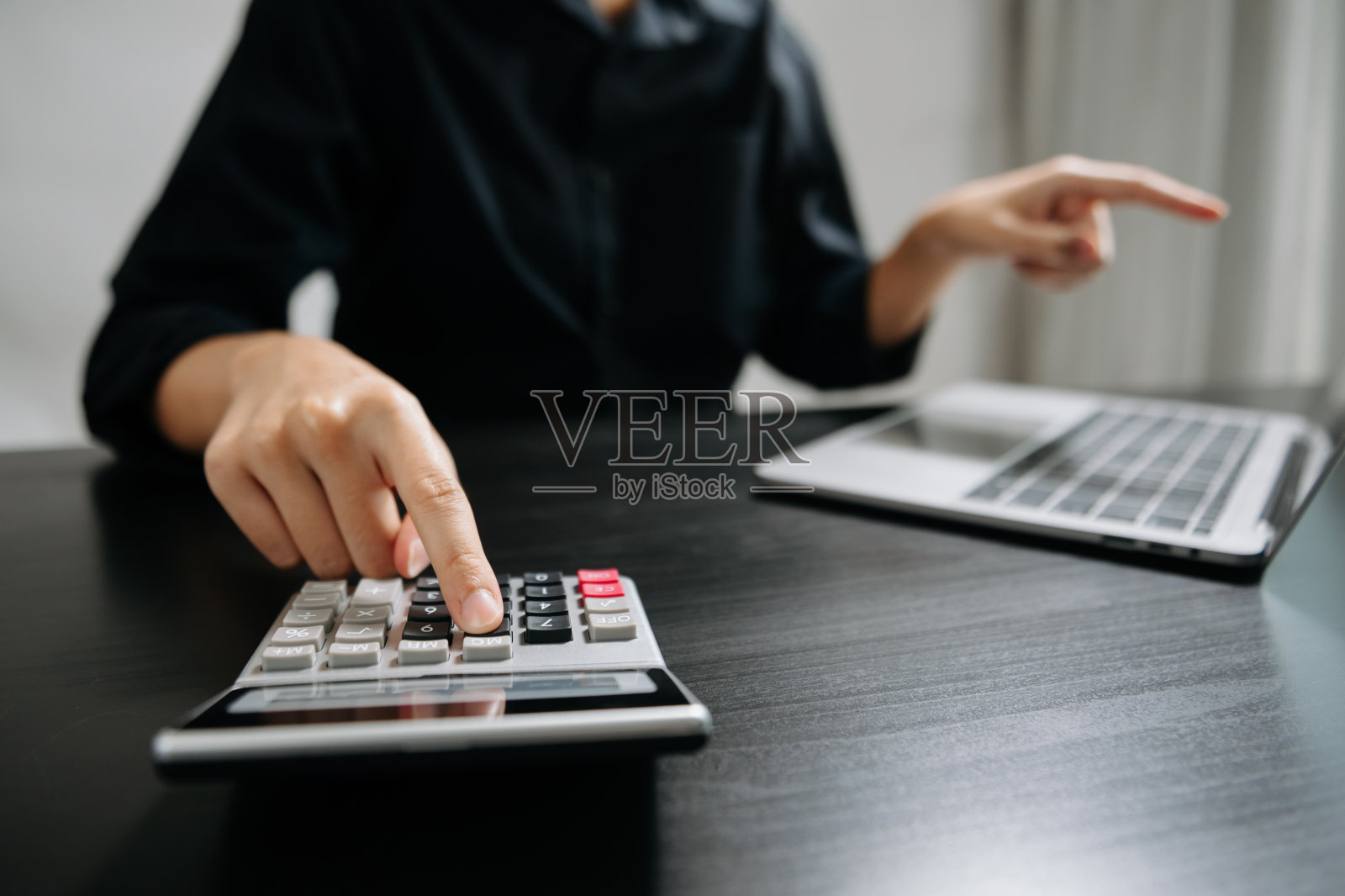 职场女性或会计近距离在办公桌上敲打笔记本电脑计算办公成本。照片摄影图片