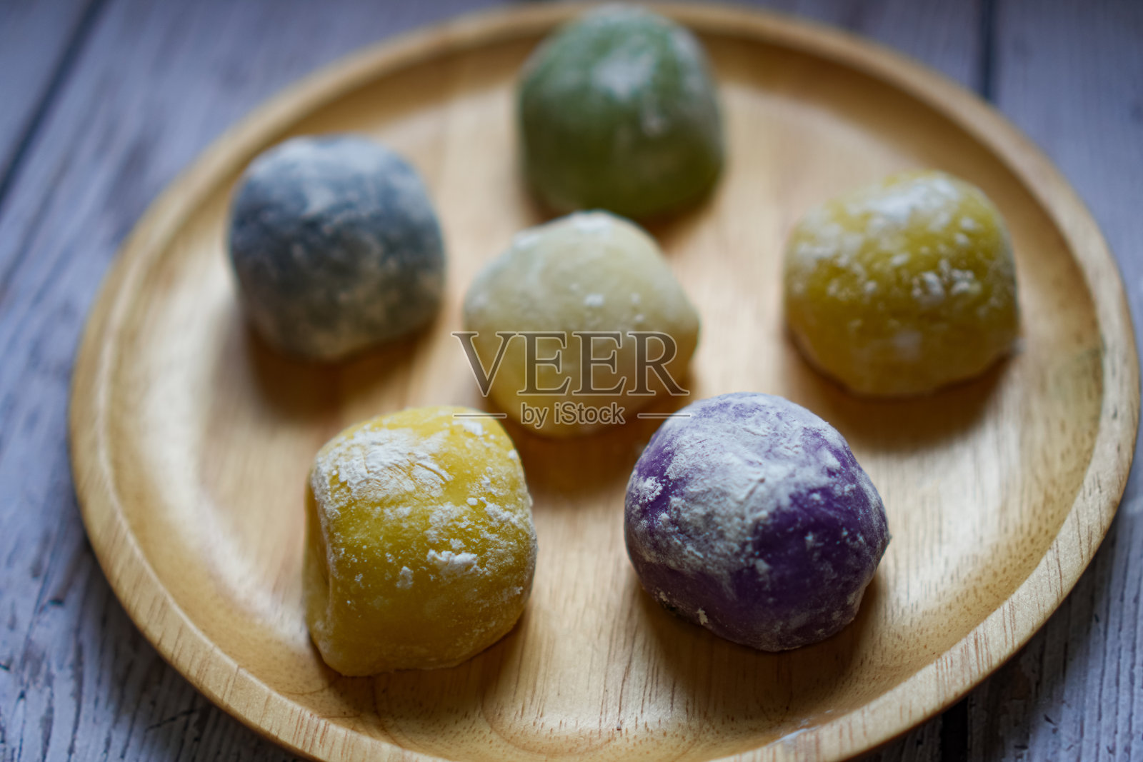 木制餐盘上五颜六色的麻糬的特写照片。照片摄影图片