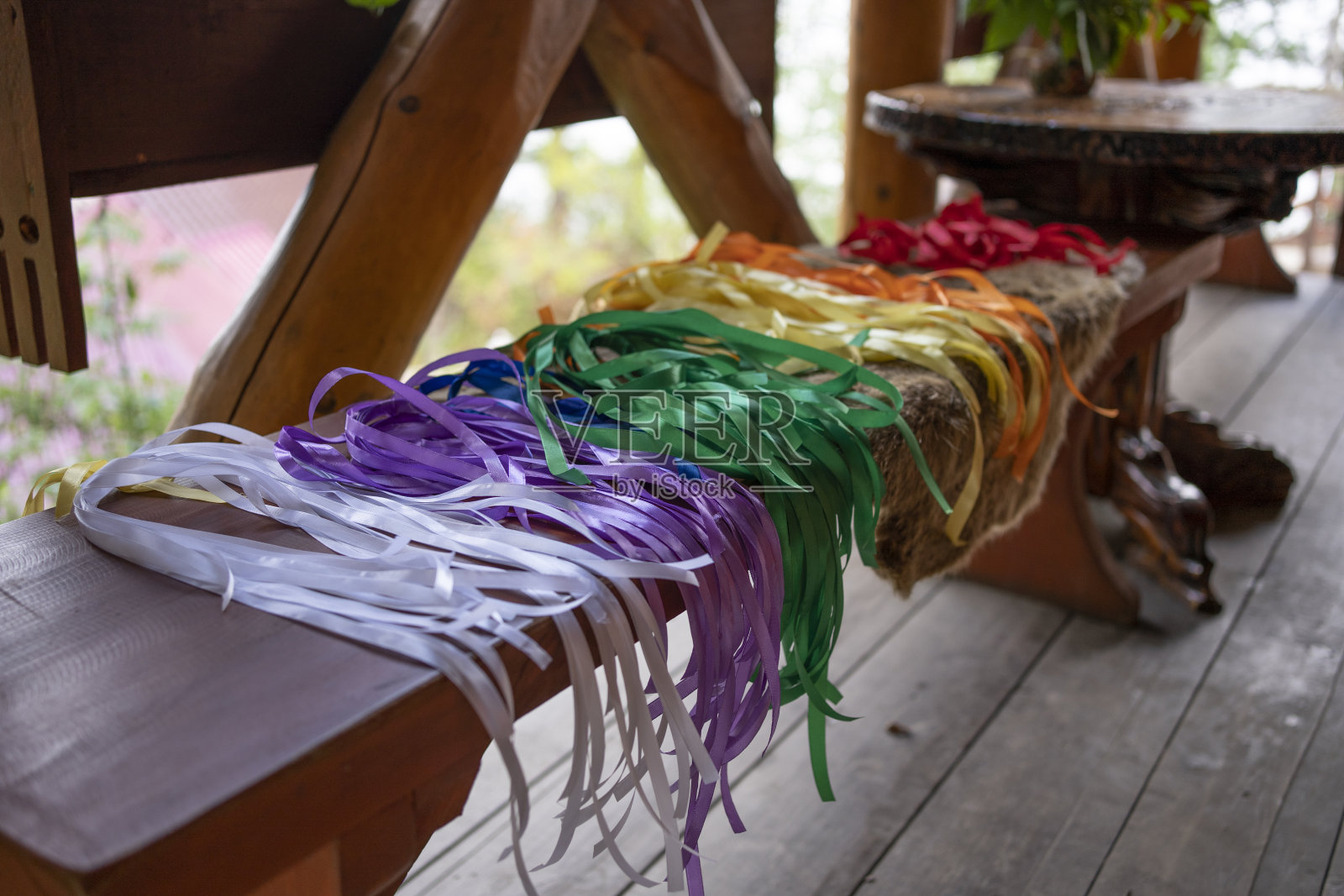 阿尔泰共和国的特列茨科耶湖。长凳上的彩色缎带。把丝带系在树上以求好运和愿望实现的传统照片摄影图片