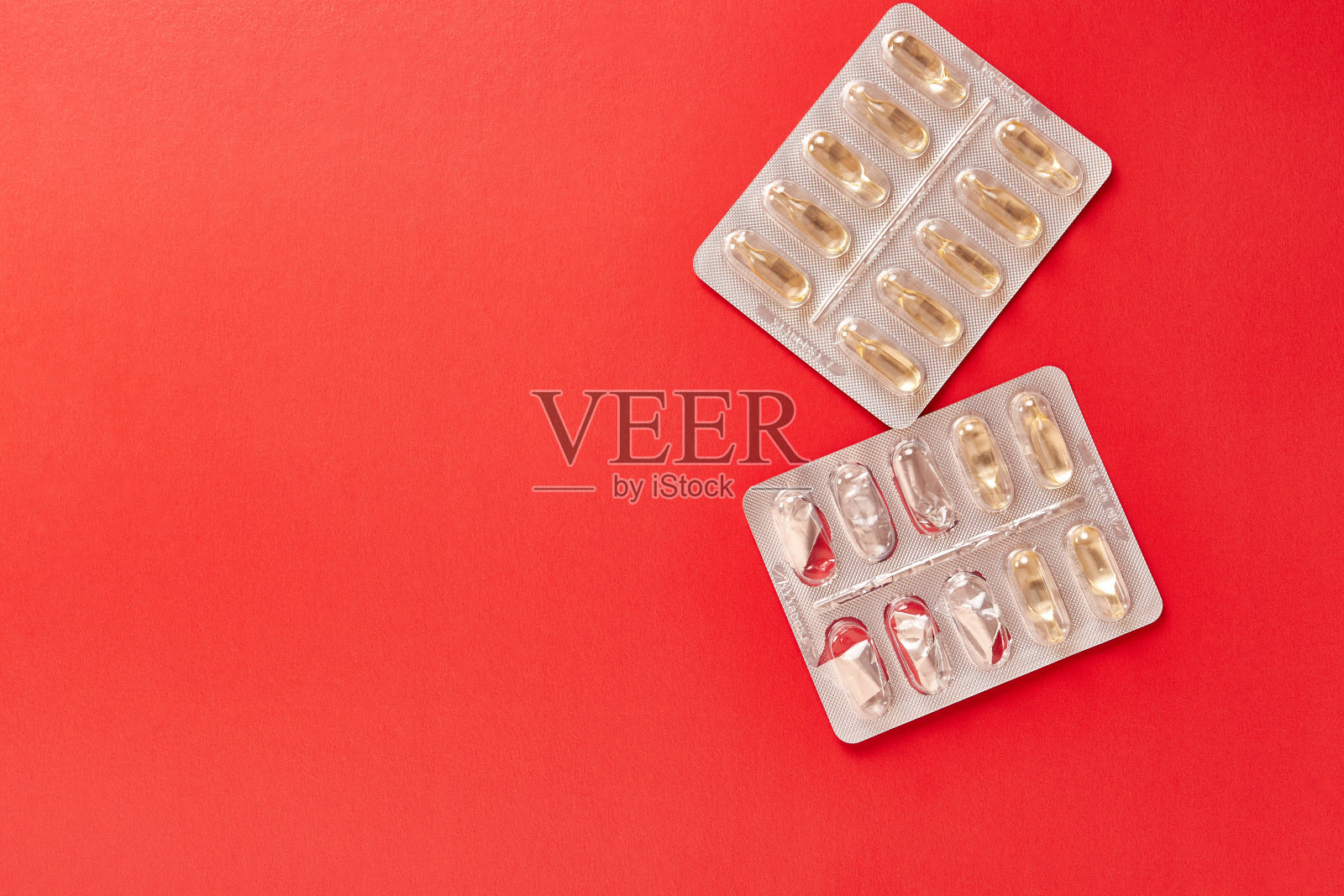 红色背景上的维生素胶囊。治疗和预防疾病。加强免疫力。照片摄影图片