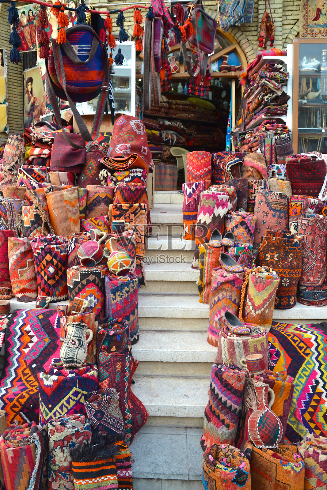 伊拉克埃尔比勒集市台阶上展示的彩色地毯、毯子和纪念品照片摄影图片