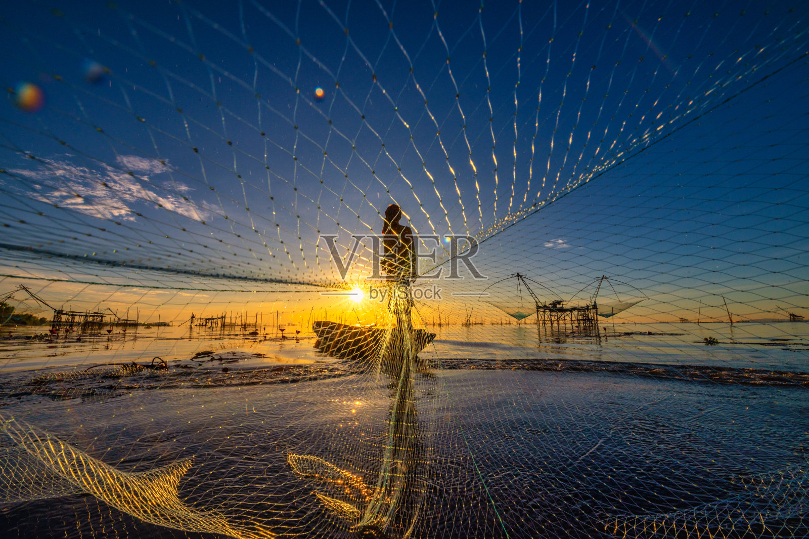 早晨，泰国帕塔隆Pakpra村的渔民在湖上撒网捕鱼照片摄影图片