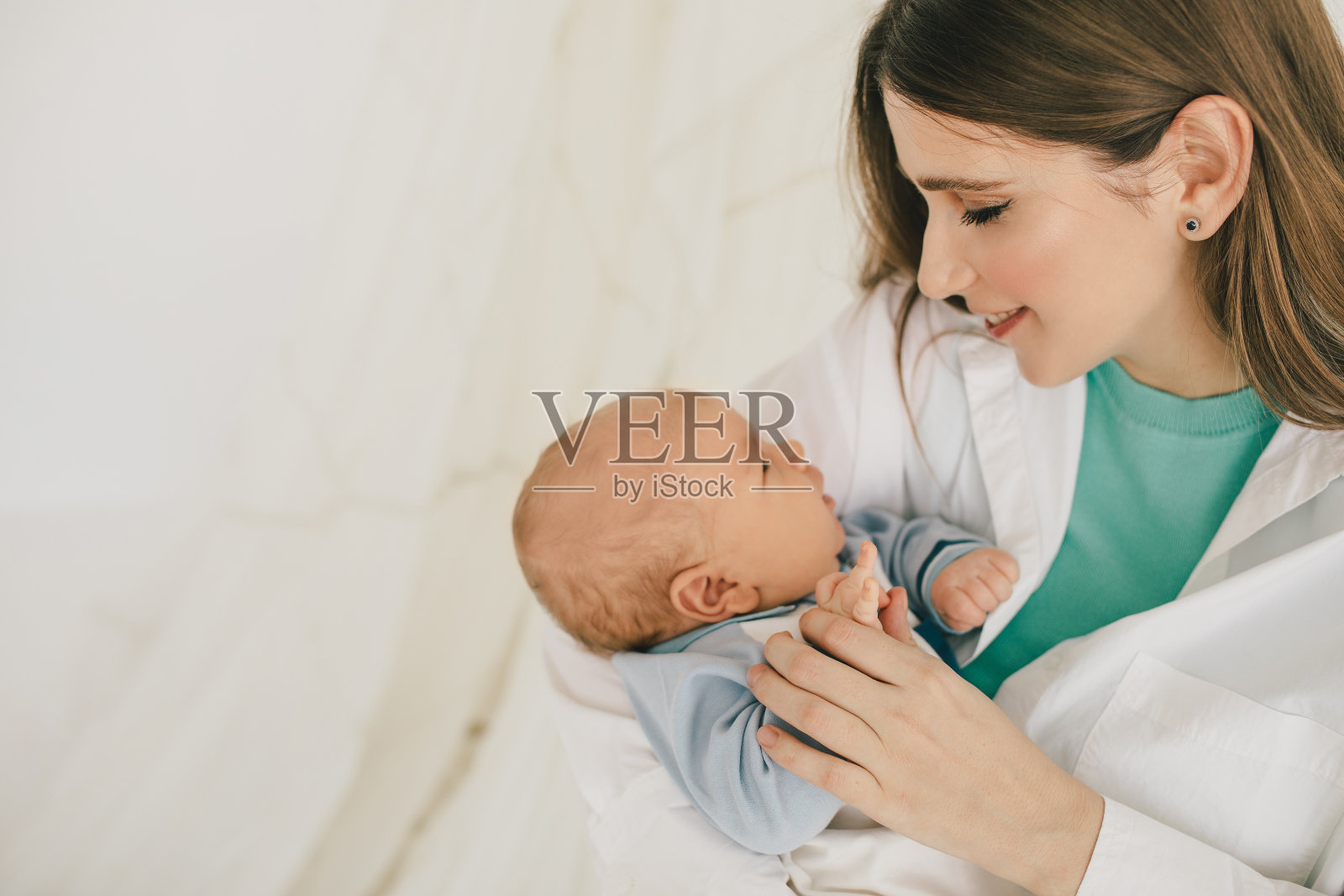 快乐的妈妈和小男孩，穿着白色背景的休闲服。照片摄影图片