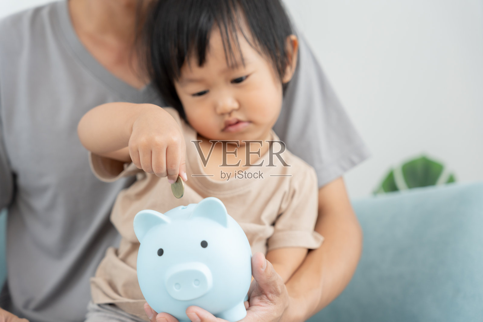 省钱。聪明的现代女性把硬币放进存钱罐里存钱。财富、金融、商业、投资、退休、未来、会计、计划人生、节约、银行、家庭、健康。照片摄影图片