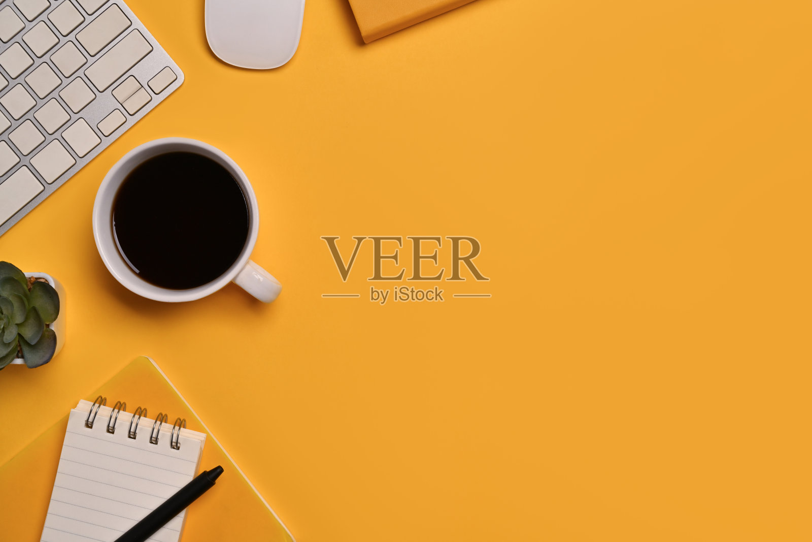 咖啡杯、记事本、键盘和鼠标在黄色背景上的俯视图。文本复制空间照片摄影图片