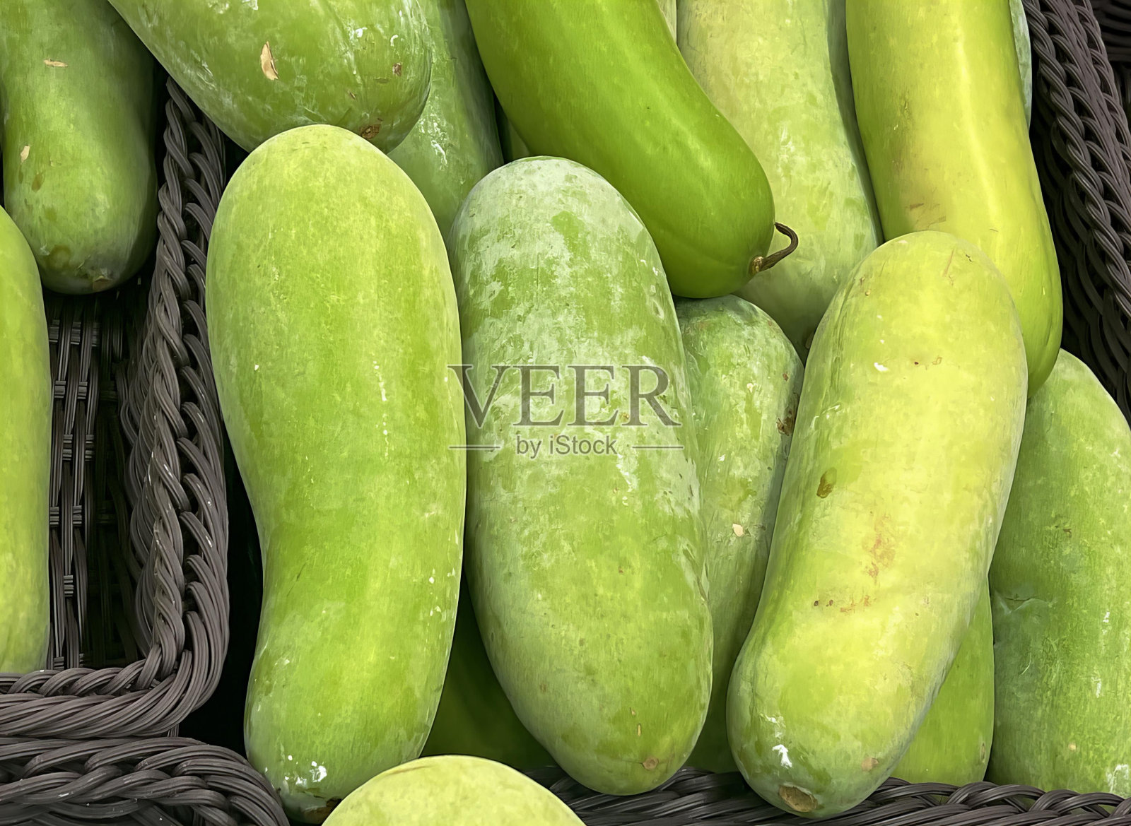 黄瓜、黄瓜、黄瓜、黄瓜和其他蔬菜放在一个篮子里。照片摄影图片