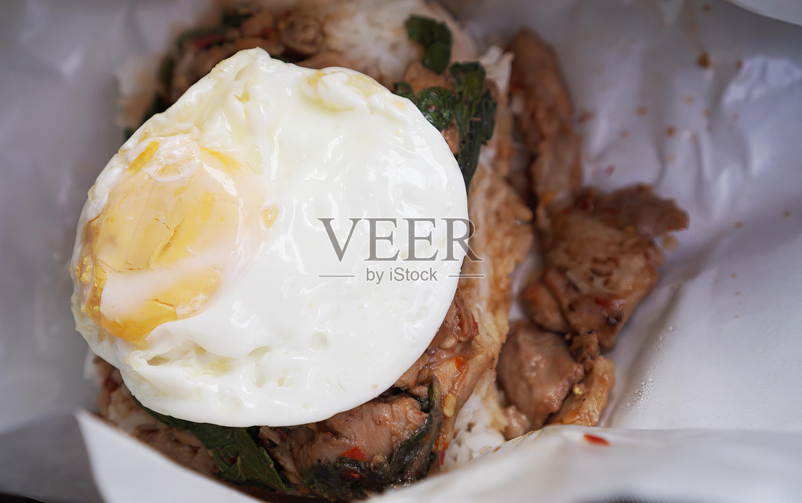 在肉和蔬菜上面放一个煎蛋。照片摄影图片