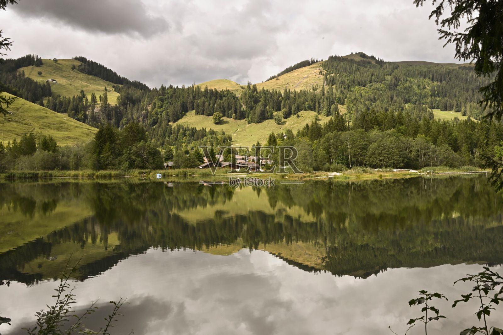 宁静的湖泊在茂密的森林覆盖的山脉之间照片摄影图片