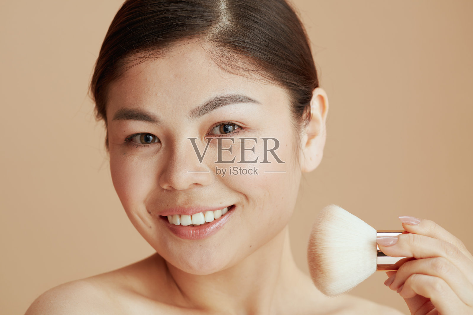 年轻的亚洲女人用化妆刷的肖像照片摄影图片