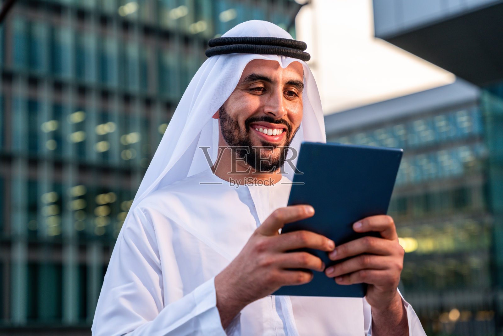穿着阿联酋传统服饰的阿拉伯中东男子在城市里照片摄影图片