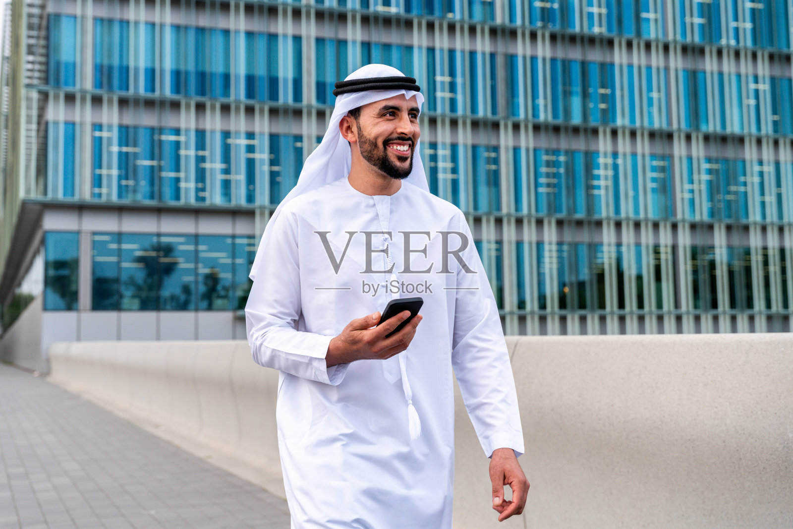 穿着阿联酋传统服饰的阿拉伯中东男子在城市里照片摄影图片