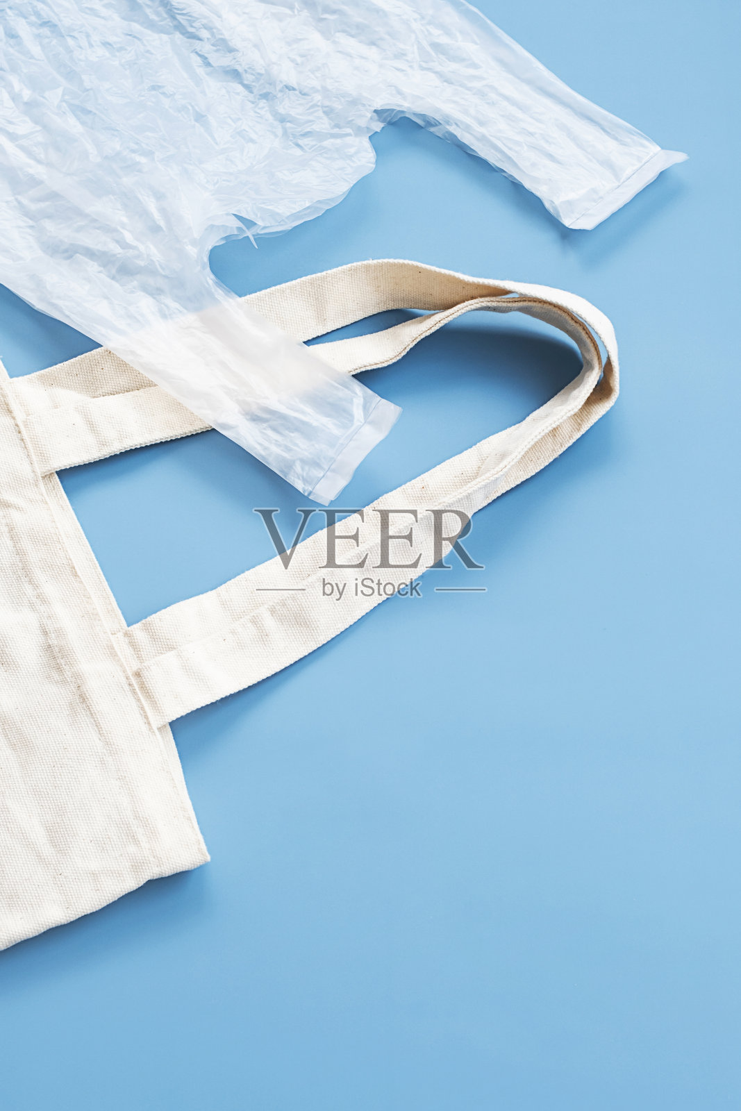 比较可重复使用的纺织袋和一次性塑料袋的概念。照片摄影图片