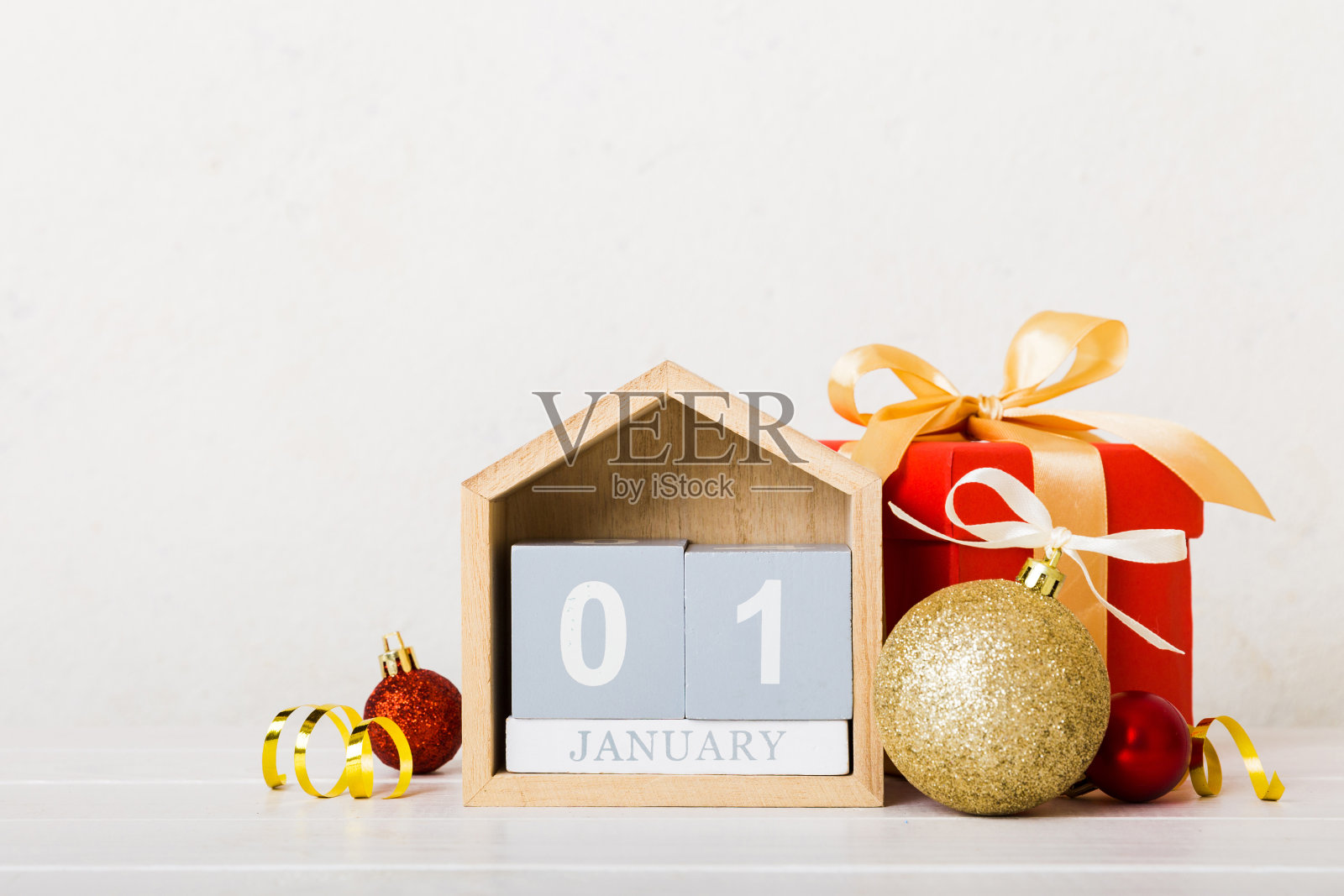 1月1日。圣诞构图在彩色背景上用木制日历，配上礼盒、玩具、小摆设的复制空间照片摄影图片