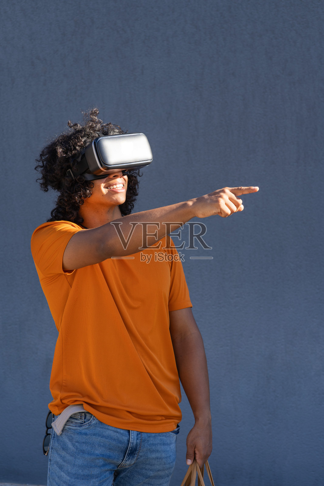 年轻的西班牙人戴着虚拟现实眼镜指着有趣的东西照片摄影图片