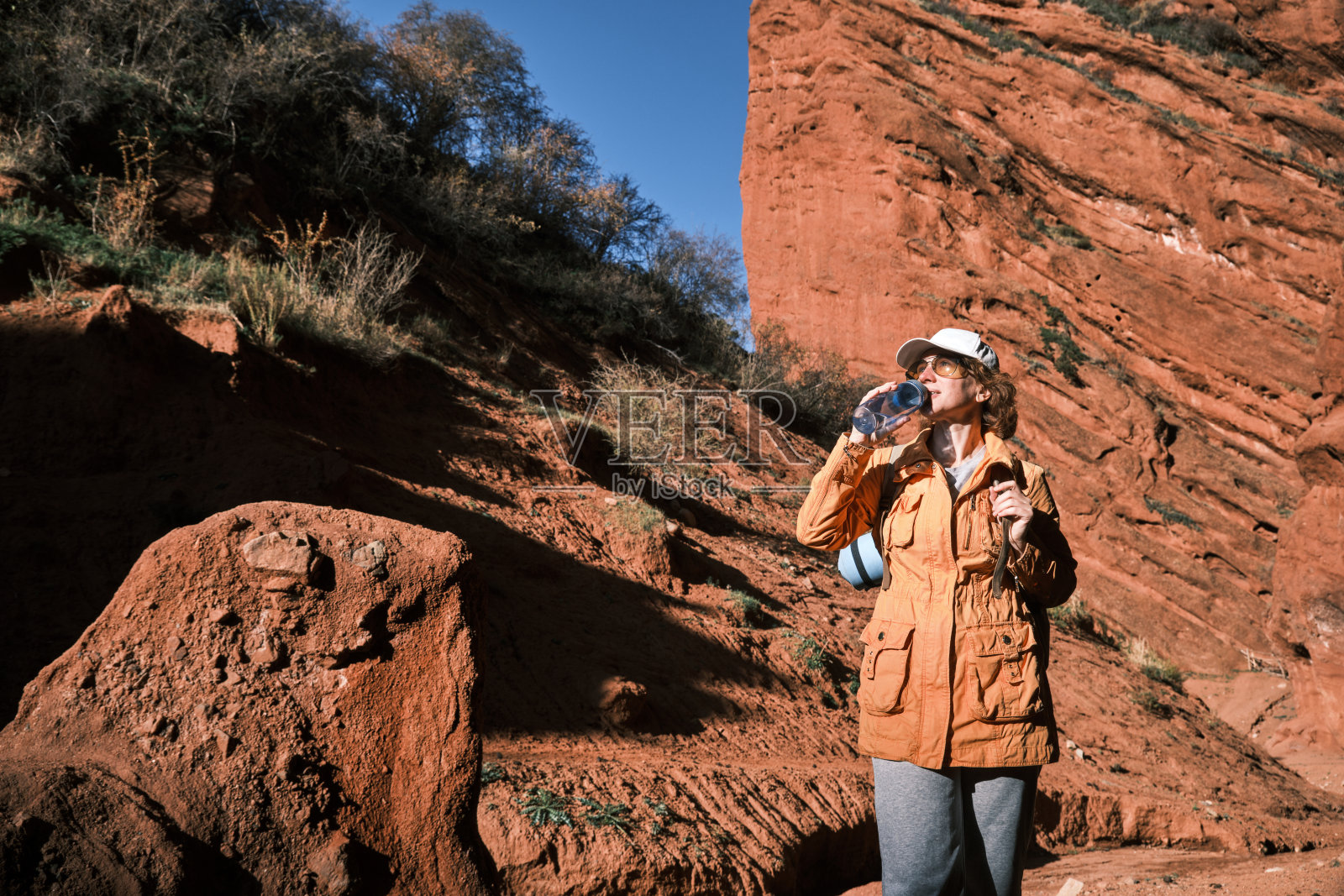 成熟的女徒步者正在红岩峡谷喝水照片摄影图片