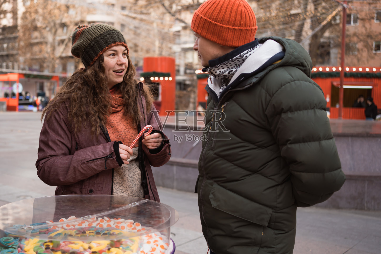 冬日假期，一对相爱的成年夫妇在街市的糖果店购买圣诞糖果照片摄影图片