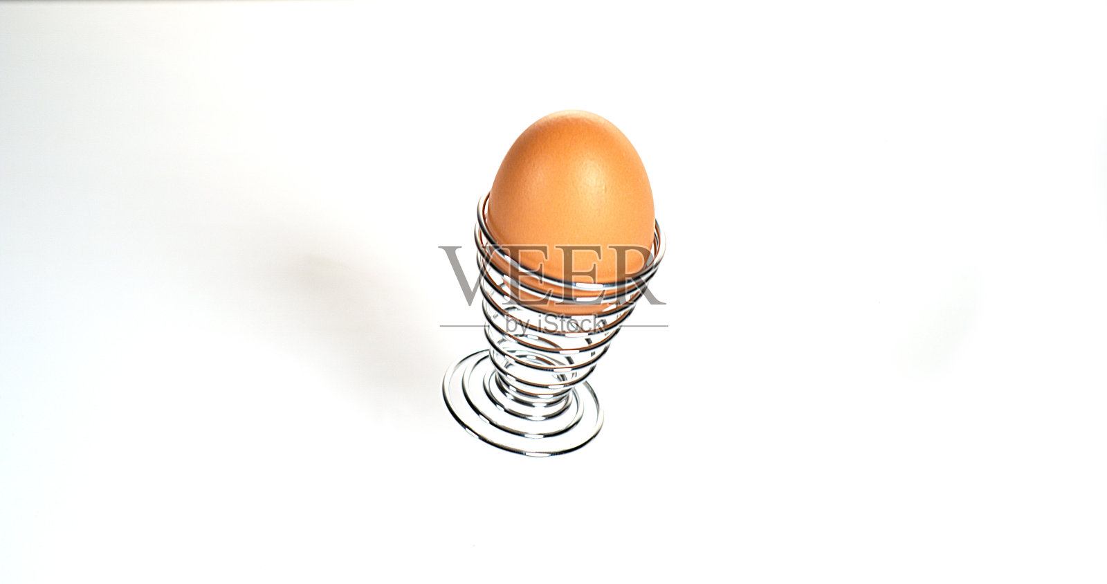 鸡蛋和蛋杯在白色背景上弹跳照片摄影图片