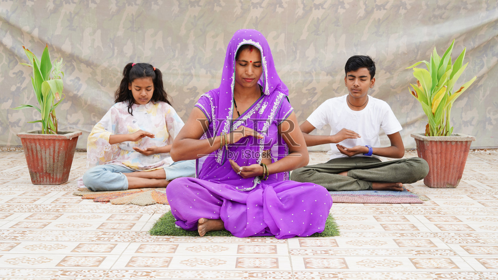 印度妇女和她的孩子在家里冥想。照片摄影图片