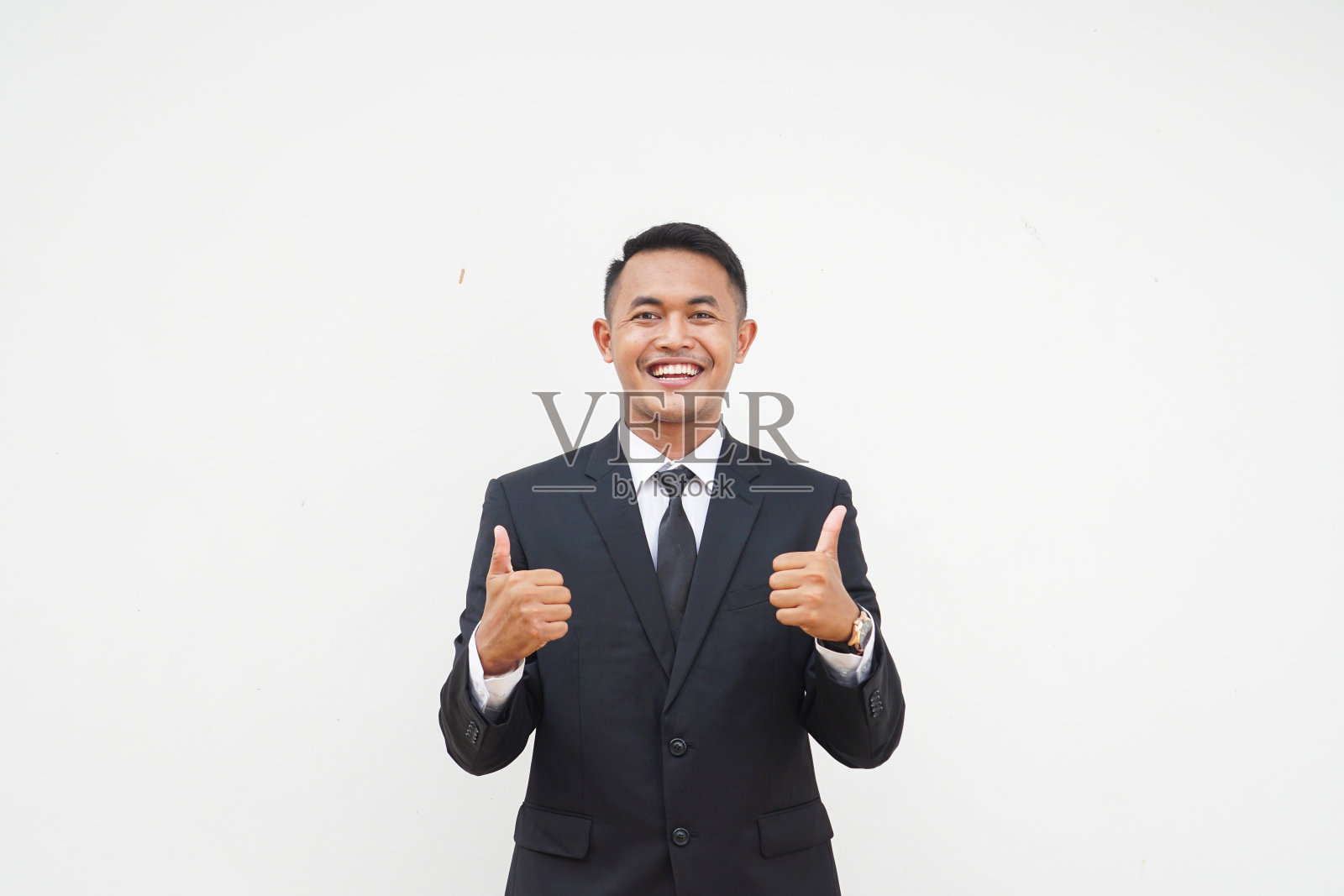 年轻的亚洲商人微笑着笑脸，竖起大拇指，赞美，同意，孤立在白色背景上照片摄影图片