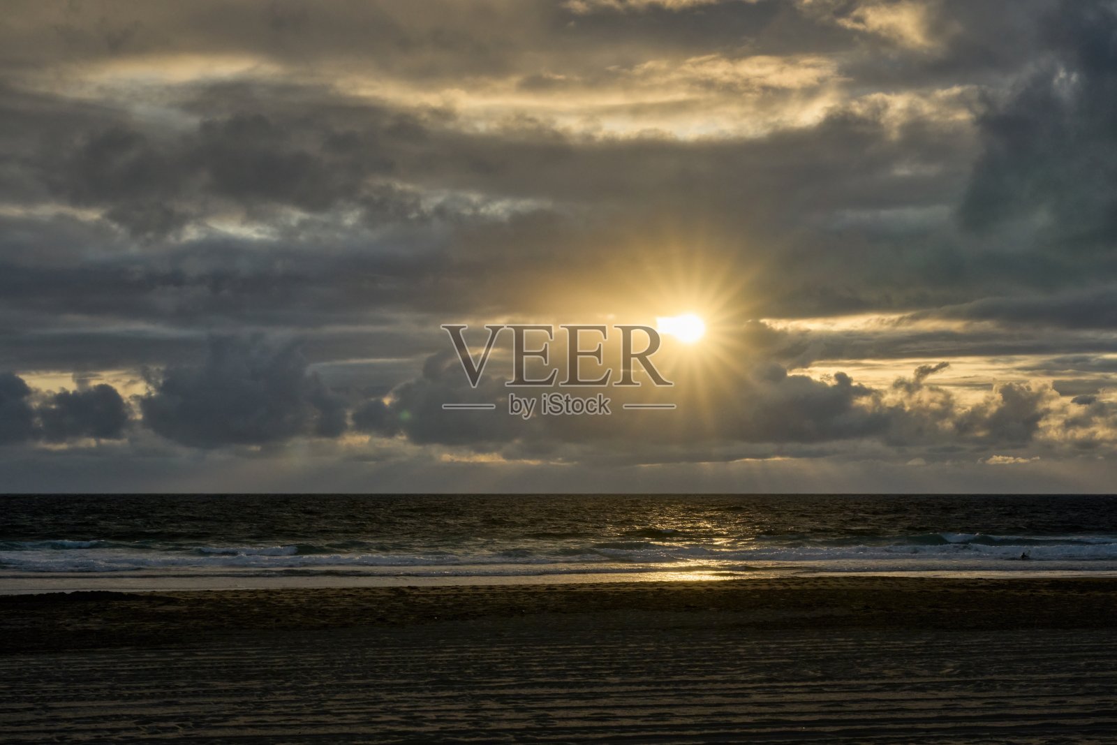 黄色的太阳在大西洋上的乌云之间闪烁照片摄影图片