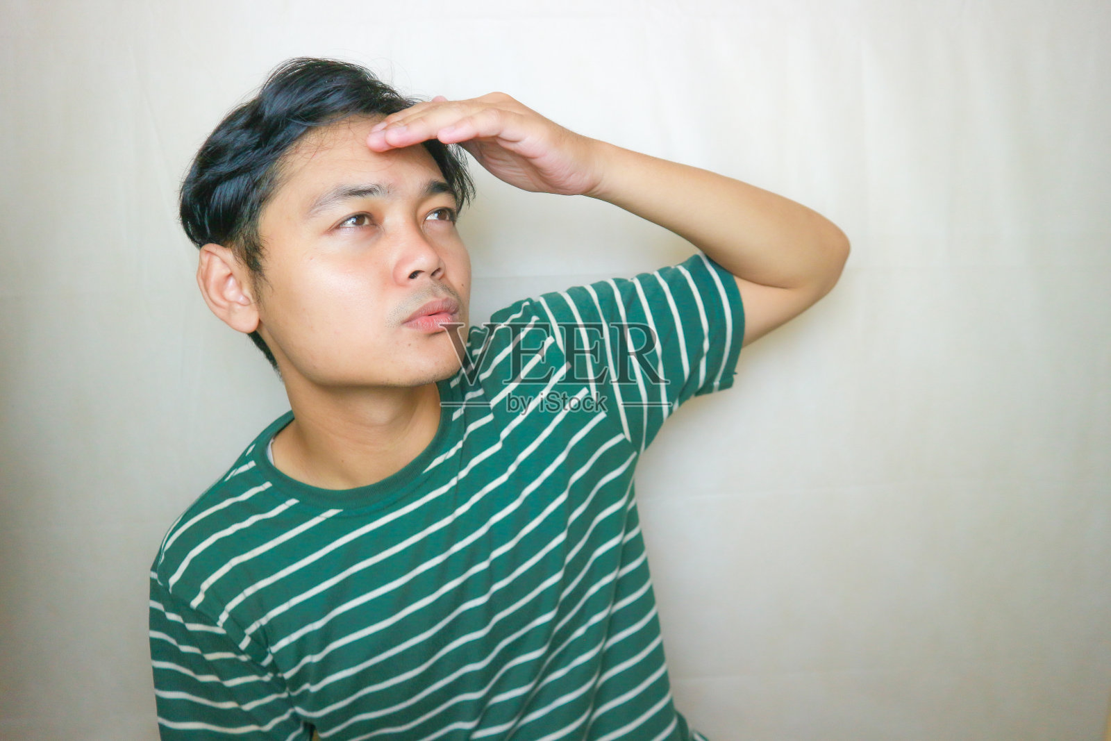 一名印尼亚裔男子身穿绿色衣服，以白色为背景，正在拍摄各种表情的照片照片摄影图片