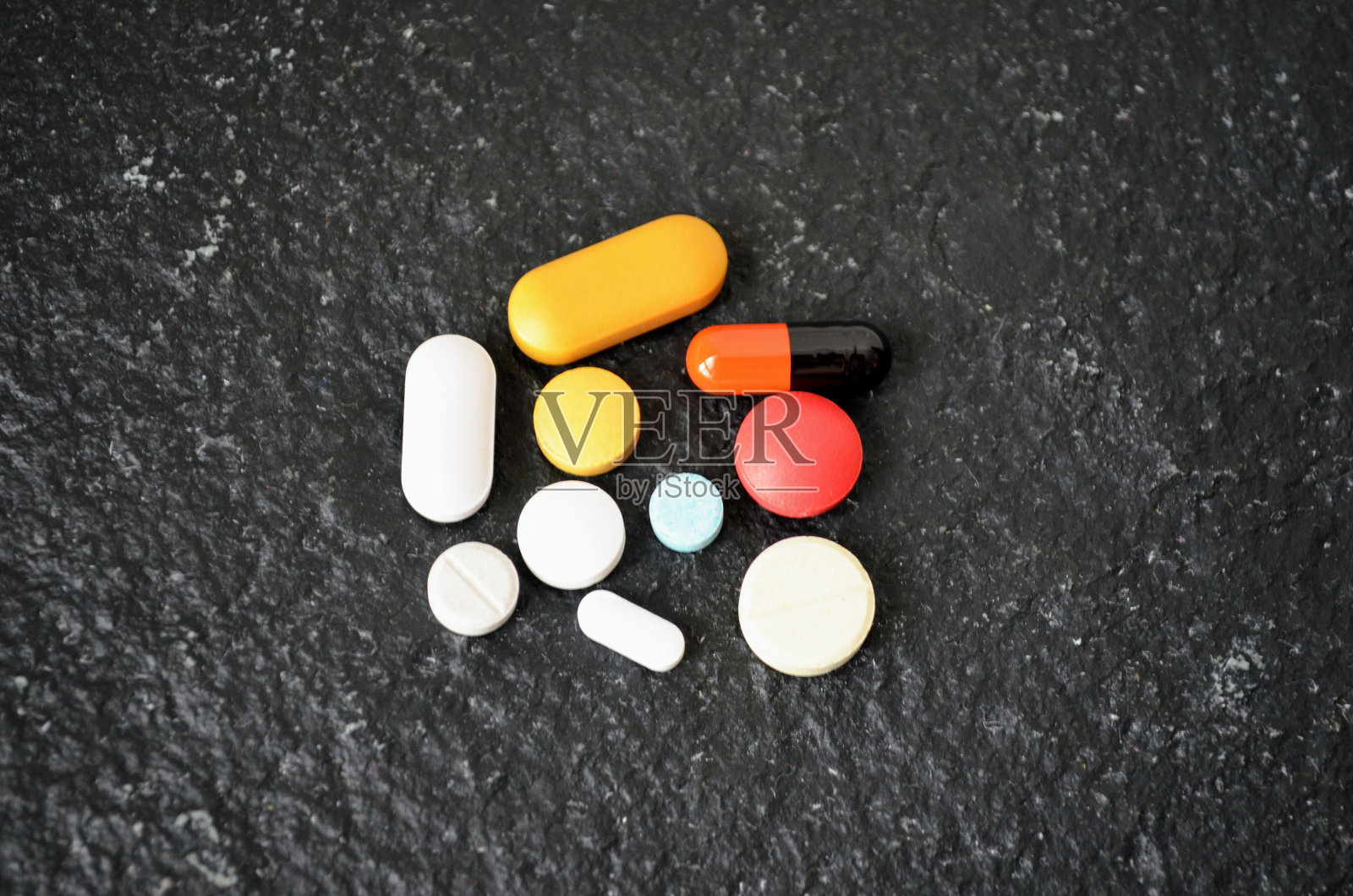 保健药片剂胶囊黑色底色。不同颜色和大小的石板。药物剂量。治疗补救丸，许多治疗处方补充。照片摄影图片