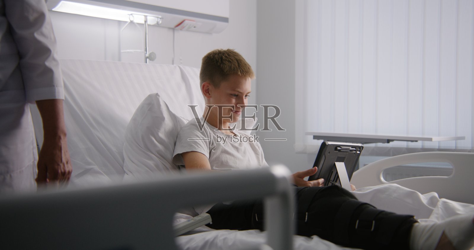 病人躺在床上，用药片和爸爸交谈照片摄影图片