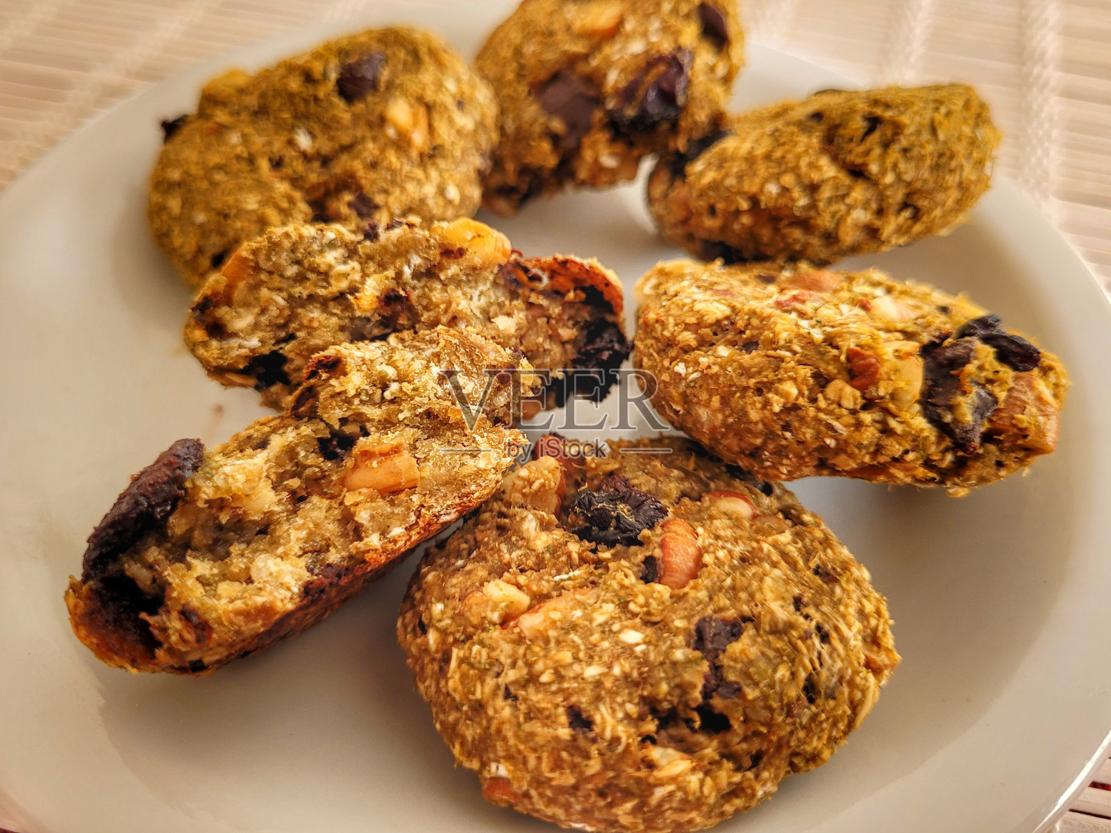 用燕麦片、磨碎的椰子、葡萄干、黑巧克力、杏仁、榛子、核桃、柠檬皮和果汁、蜂蜜、香料和马黛茶制成的手工饼干照片摄影图片