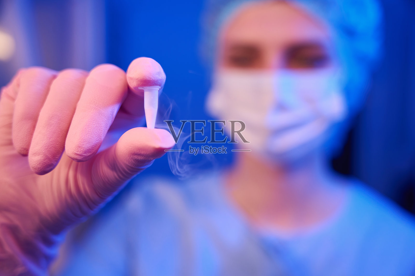 实验室科学家展示装有冷冻卵子样本的低温瓶照片摄影图片