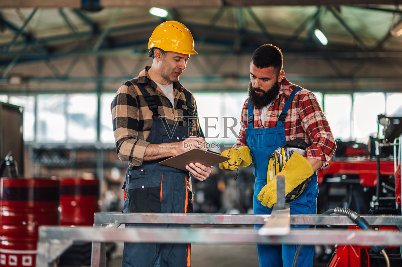 同事们一起工作，在研磨金属之前阅读计划照片摄影图片