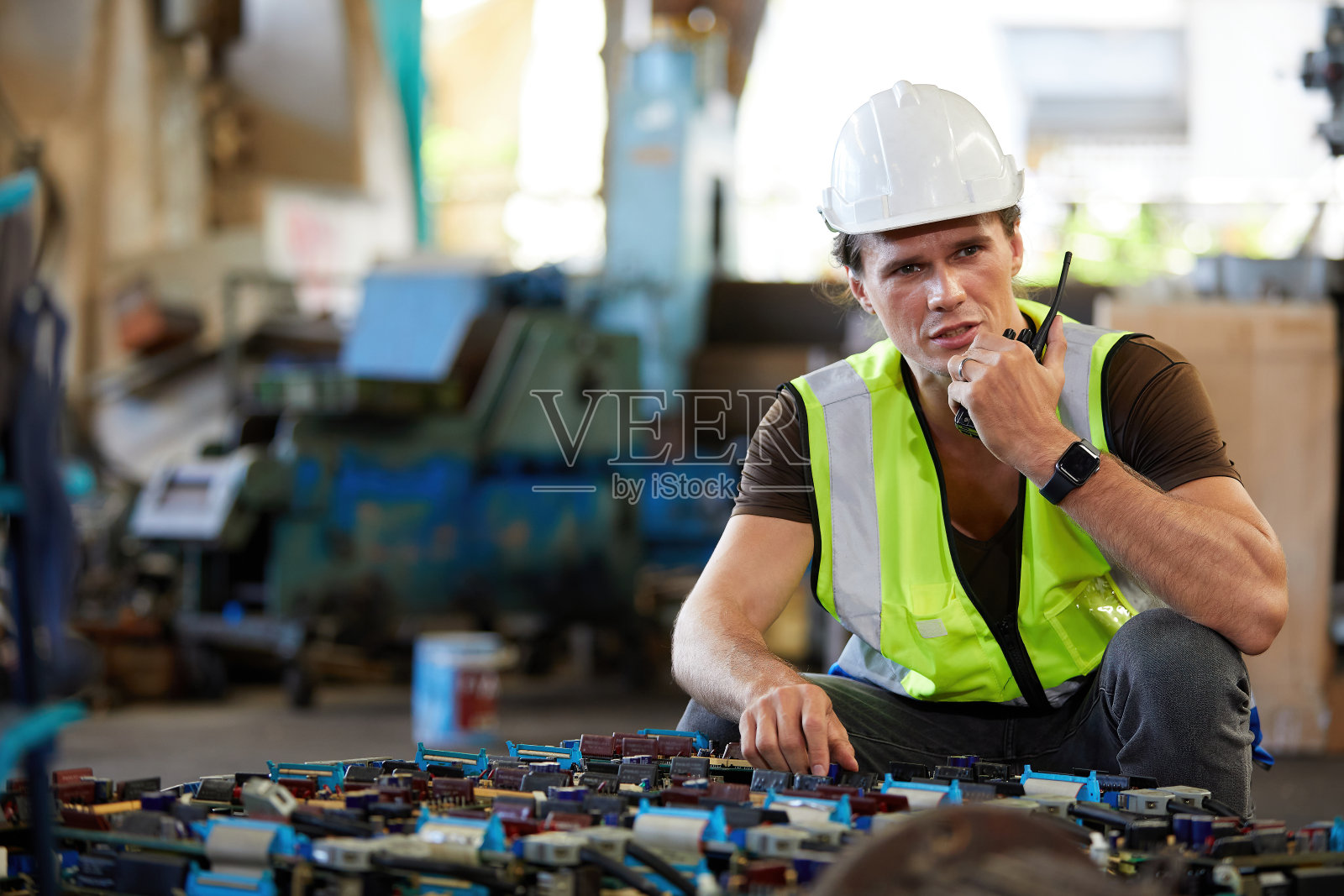 工程师或工人在工厂里用对讲机讲话和修理机器照片摄影图片