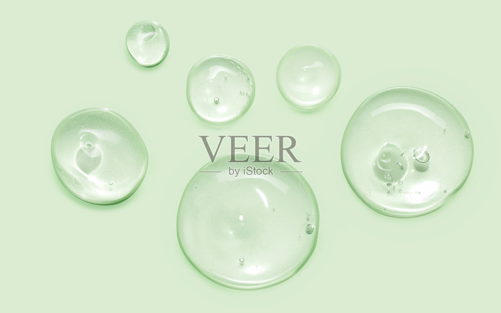 血清油样品样本圆形纹理分离在柔和的绿色背景。化妆品透明质酸视黄醇胶原蛋白科学实验室产品照片摄影图片