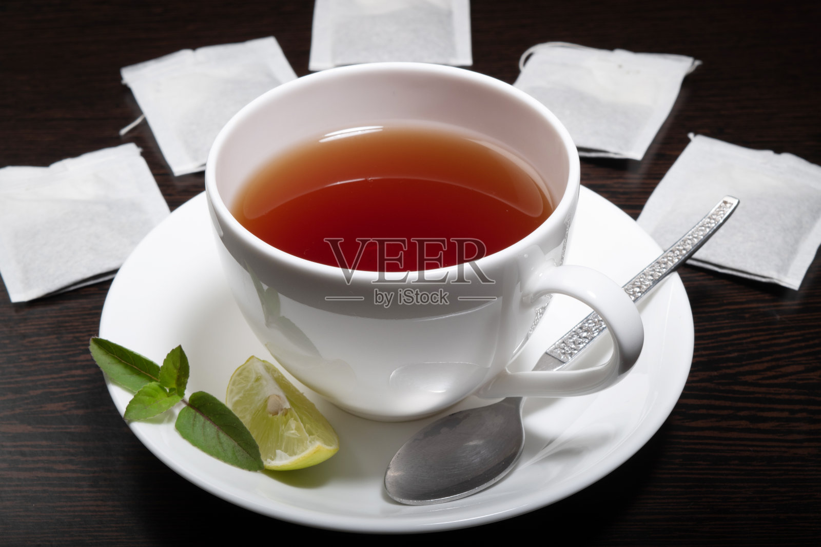 柠檬茶杯和茶包放在桌子上照片摄影图片