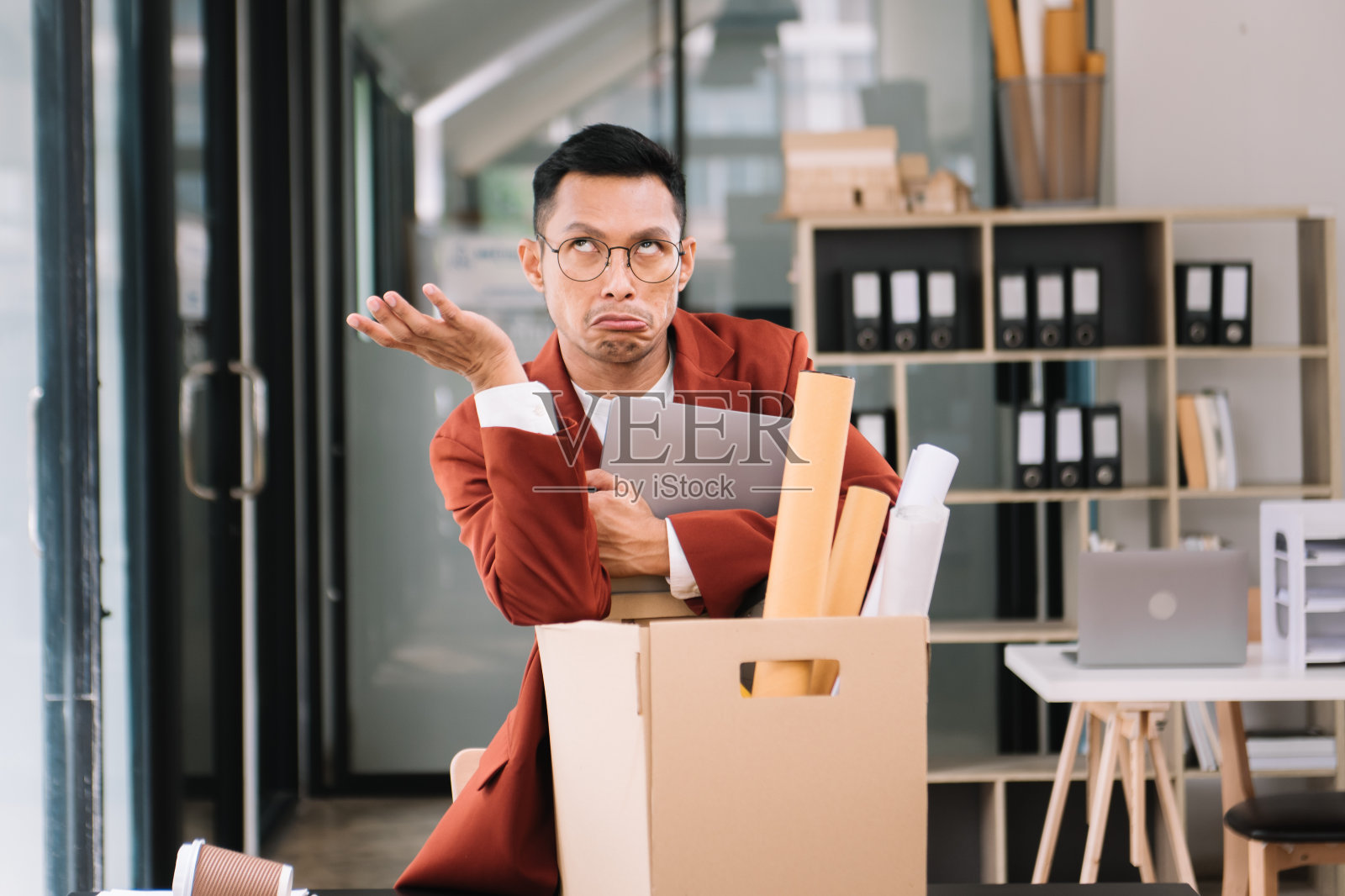 快乐和兴奋的年轻漂亮的亚洲男人办公室职员庆祝她的辞职，拿着她的私人物品。离职，换公司。照片摄影图片