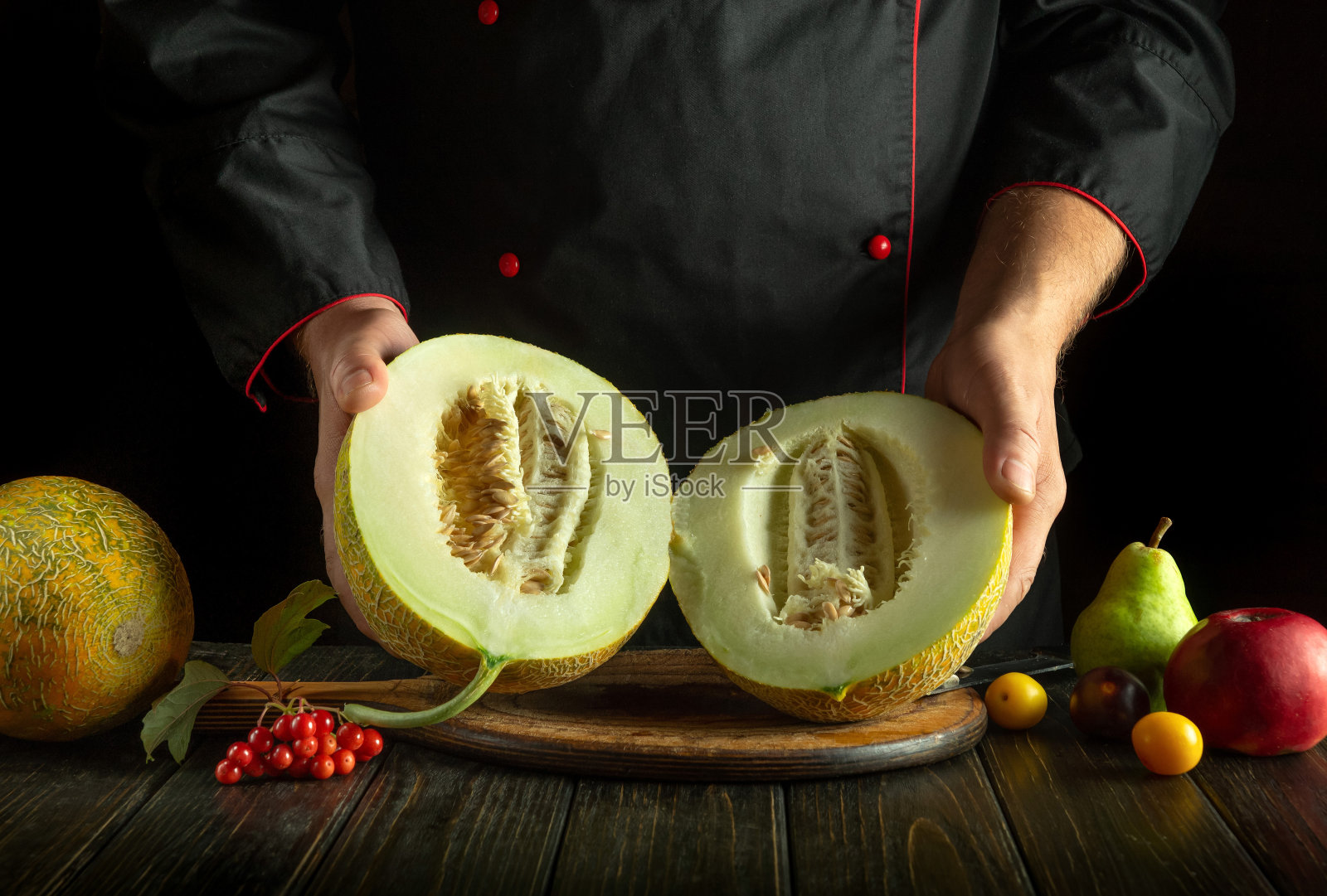 切熟的瓜在厨师的手中放在厨房的桌子上。餐厅厨房的水果饮食概念。亚洲民族菜照片摄影图片