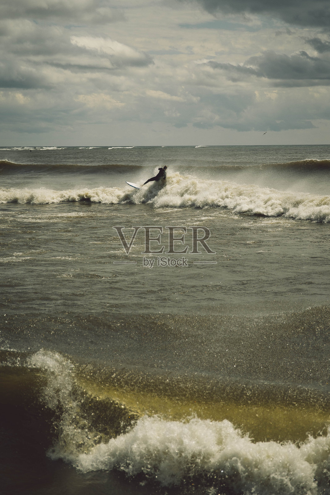 暴风雨来临前，在充满泡沫的海面上冲浪照片摄影图片