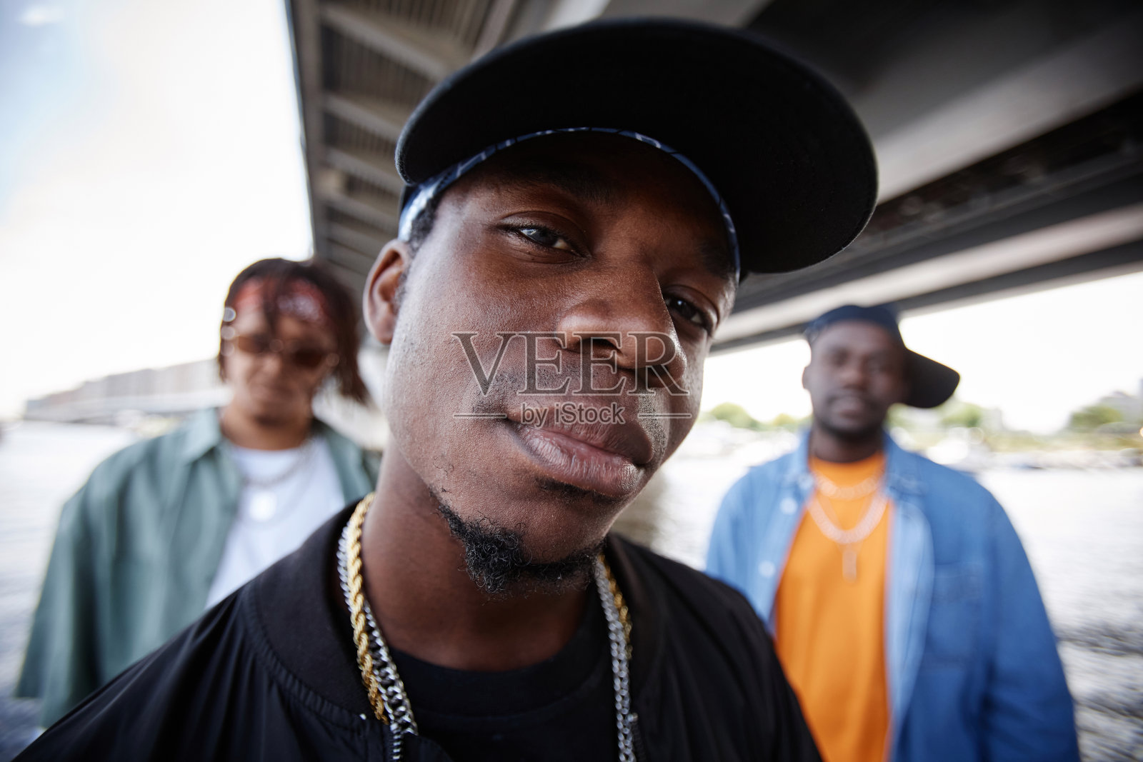 年轻时尚的嘻哈男孩乐队队长戴着黑色的帽子看着镜头照片摄影图片