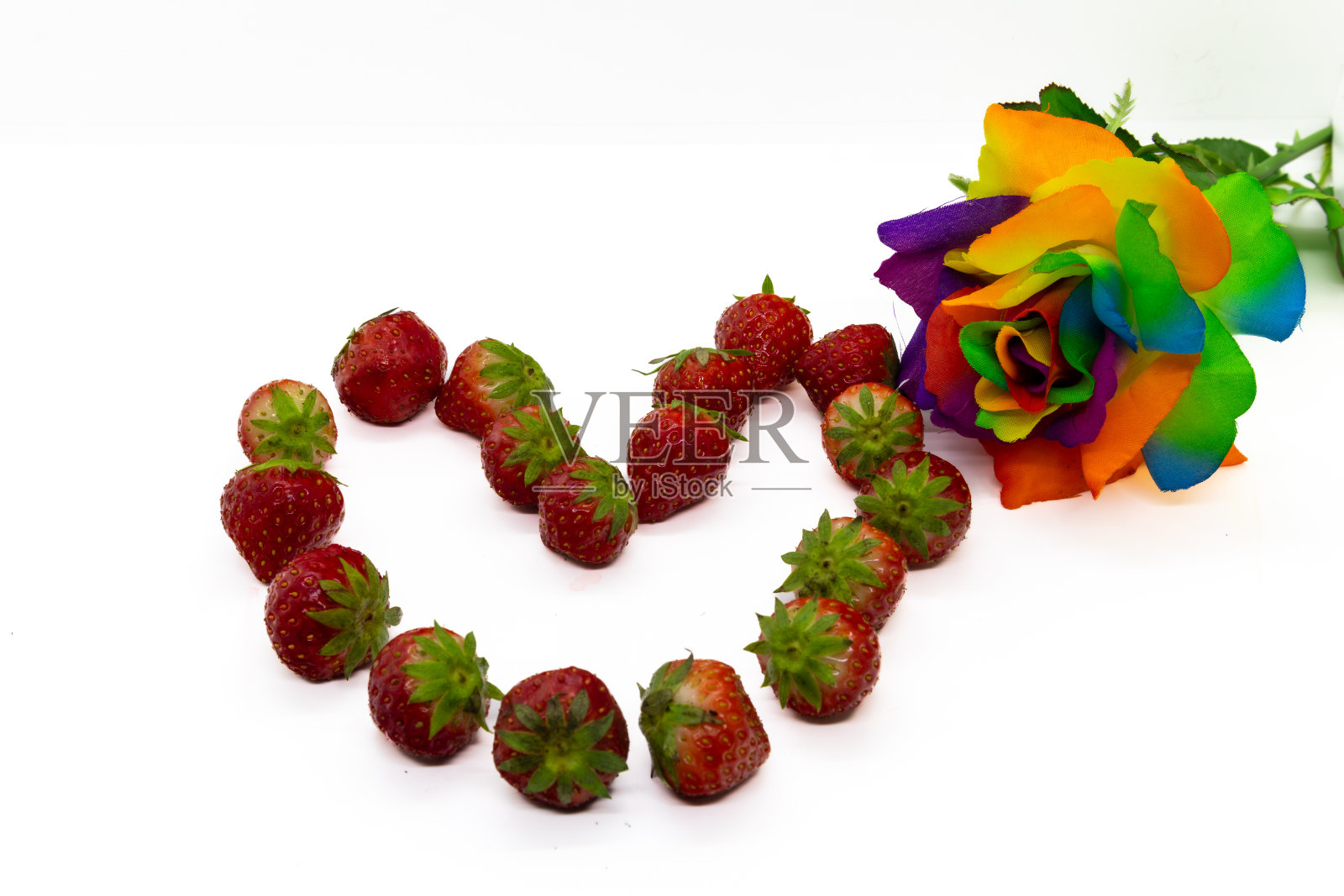 草莓在心形形成与彩虹玫瑰孤立在白色照片摄影图片