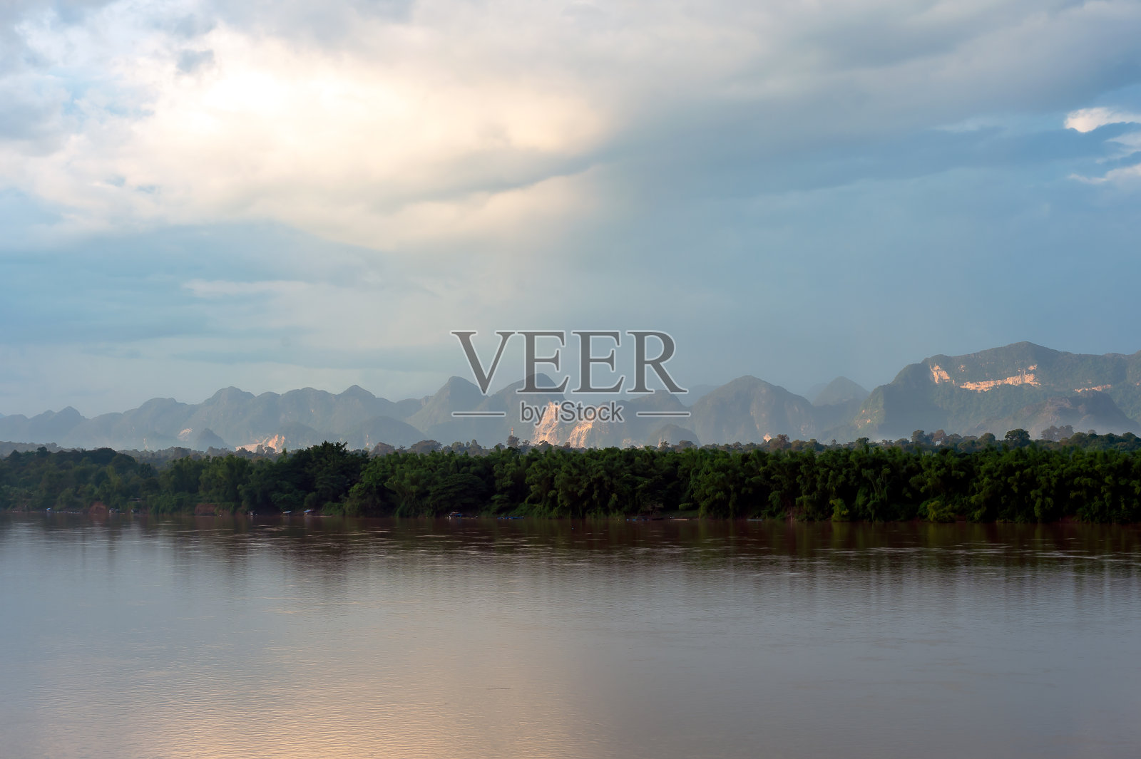 日出时风景优美，橘黄色的太阳看到群山，层叠在一起，沿河近林。照片摄影图片