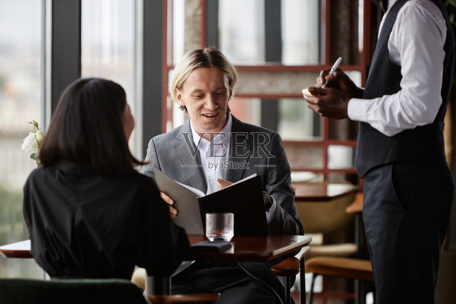 一对夫妇在餐厅点餐，金发男人拿着菜单照片摄影图片