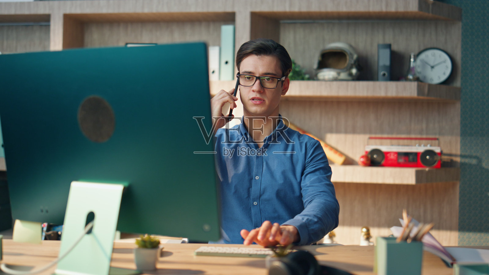 严肃的创业者在公司办公室打电话。男式打字键盘照片摄影图片