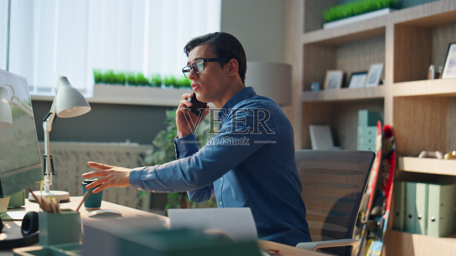 创意商人在工作场所喝茶特写。自由职业者通话电话照片摄影图片