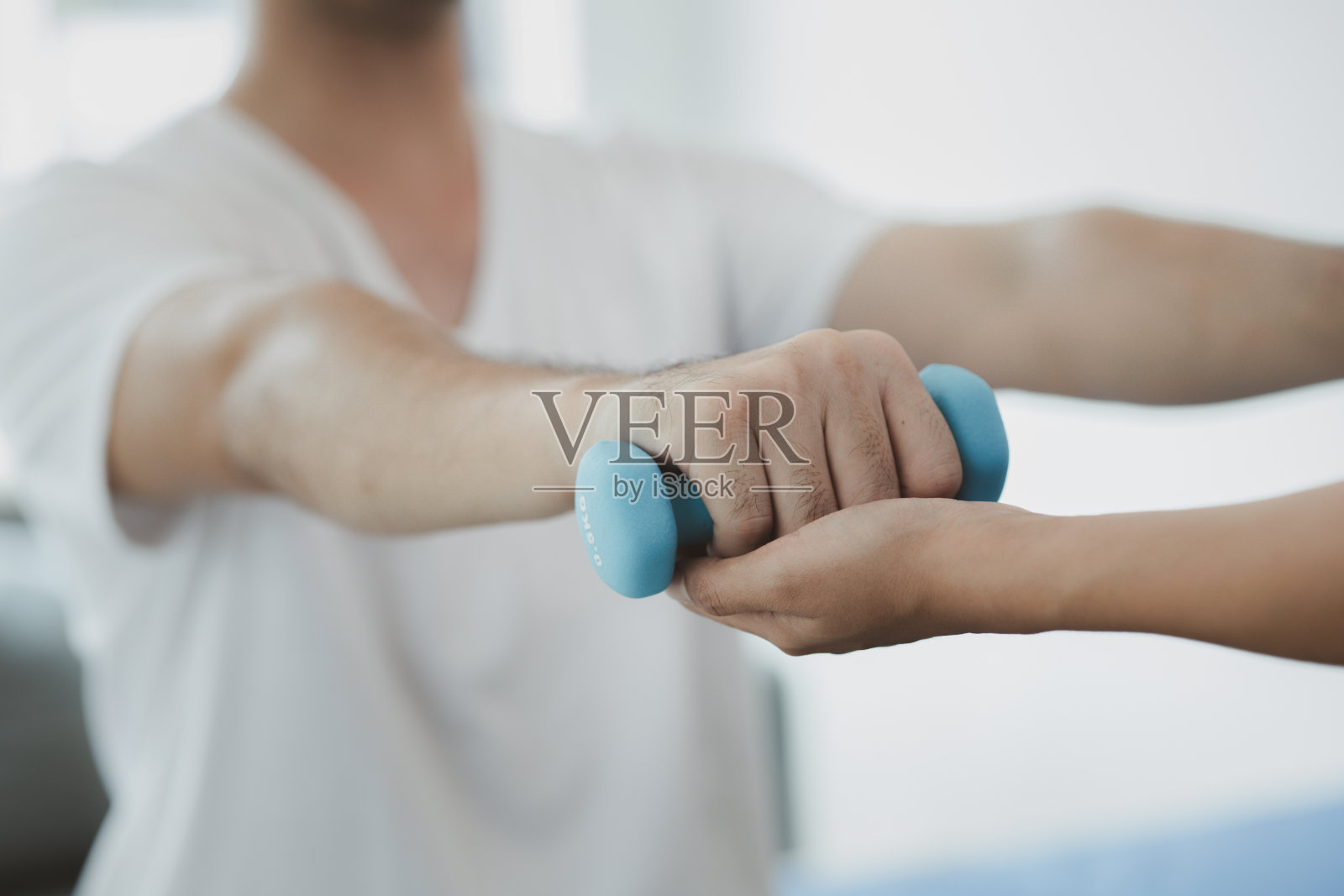 理疗师在病房里为病人做物理治疗，物理治疗通过运动身体和肌肉来帮助病人康复。用物理疗法治疗疾病的概念。照片摄影图片