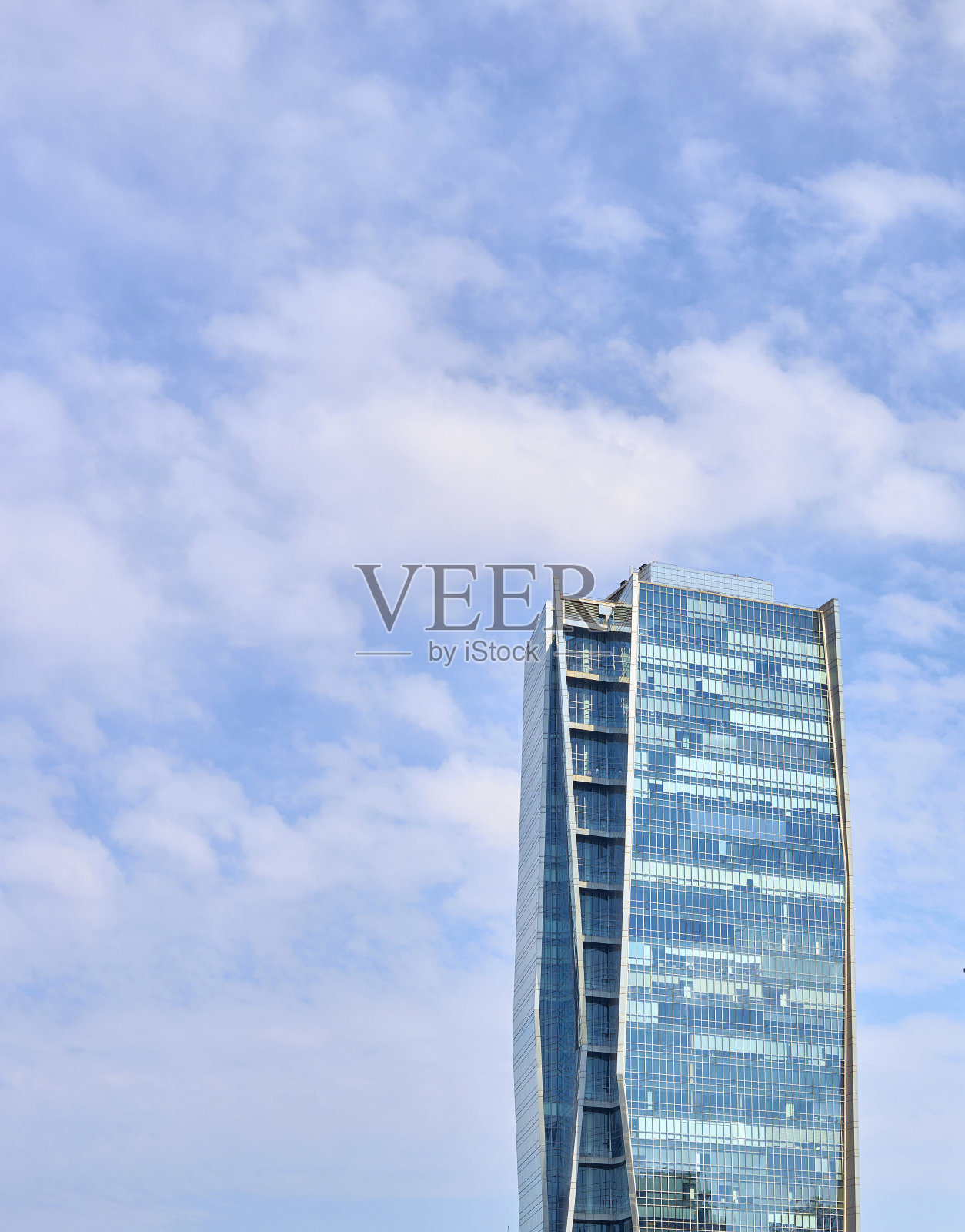 多云蓝天上的玻璃现代建筑照片摄影图片