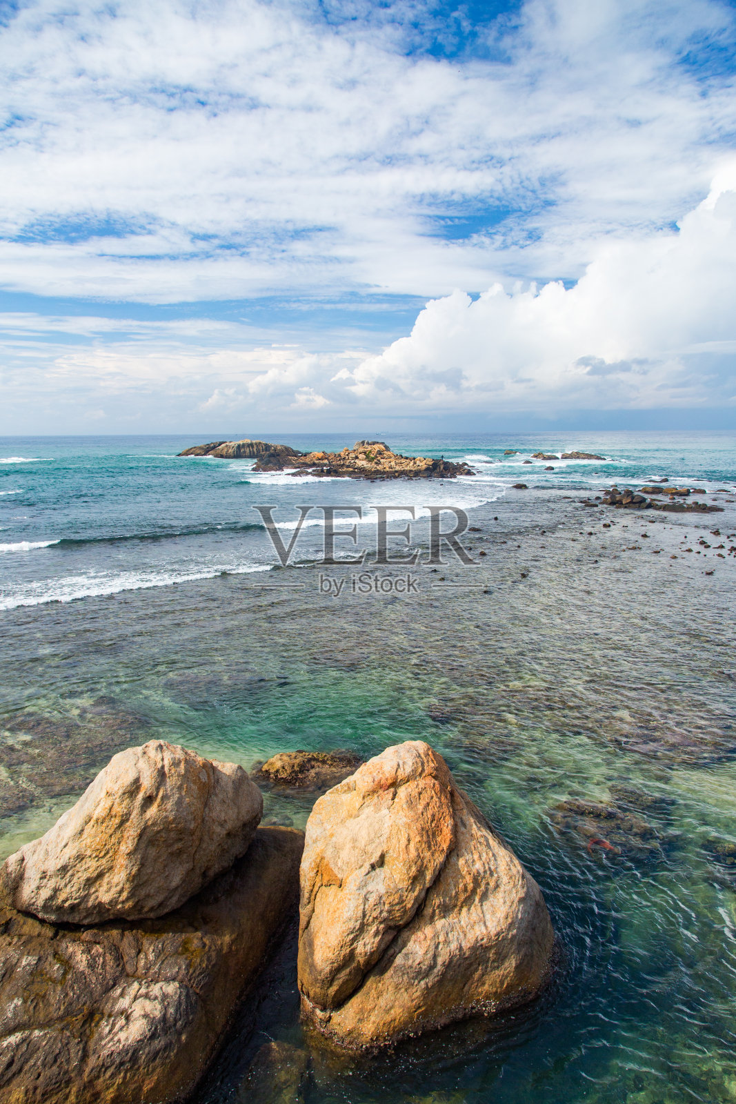 斯里兰卡加勒，有蓝天白云的岩石海岸线。照片摄影图片