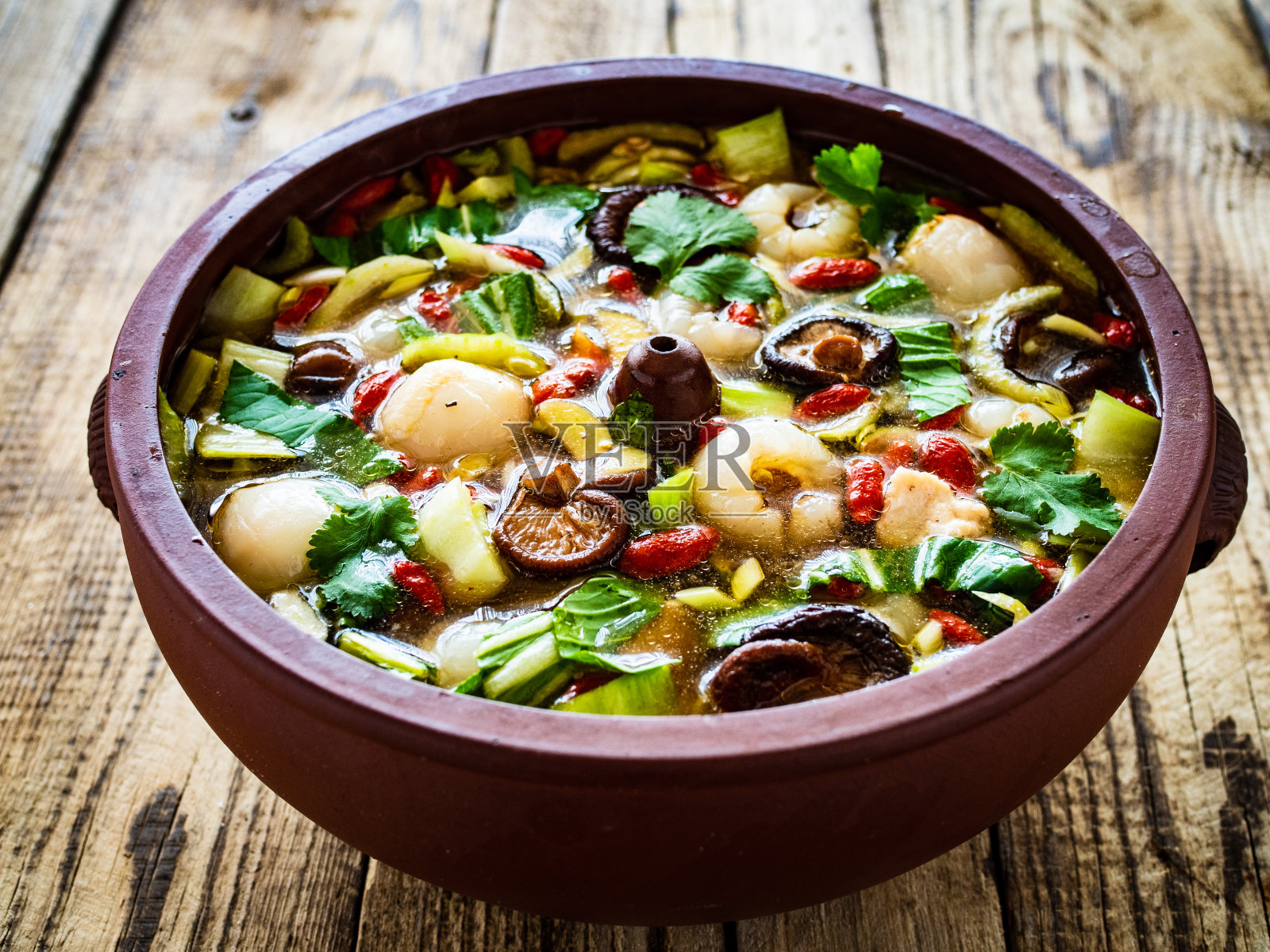 云南甜汤——用鸡肉、米粉、荔枝和枣子做成的木桌汤照片摄影图片