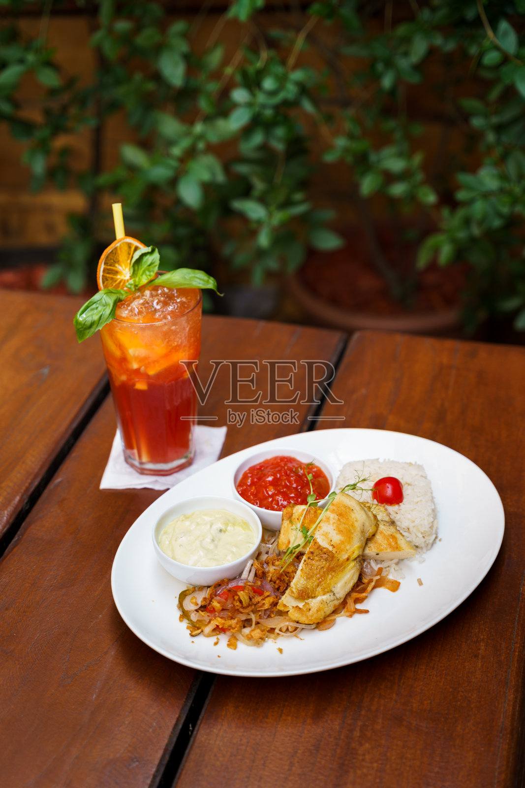 烤鸡胸肉配米饭、炸洋葱、莎莎酱和牛油果酱配柠檬水照片摄影图片