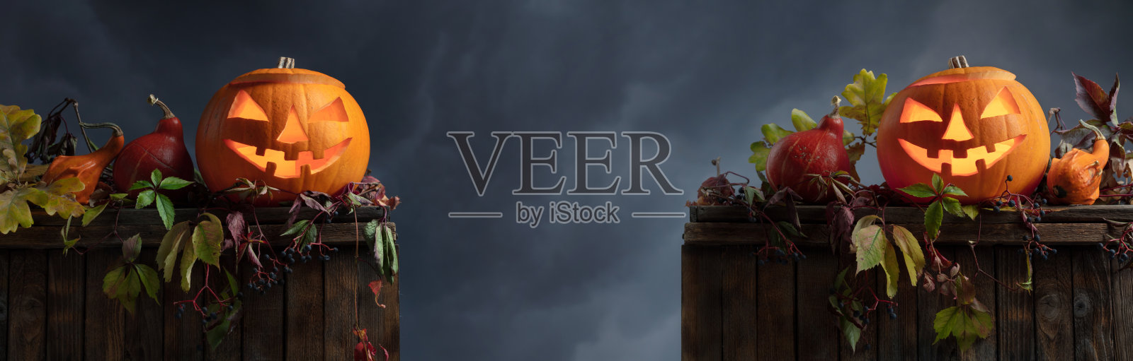 万圣节南瓜头杰克灯笼用干叶子。照片摄影图片